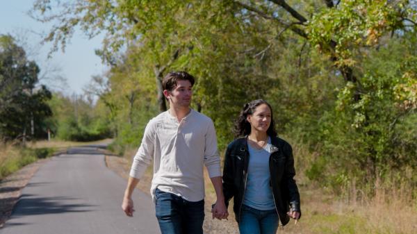 A couple holds hands as they walk a trail at Torriane Lake, Fort Smith, Arkansas.