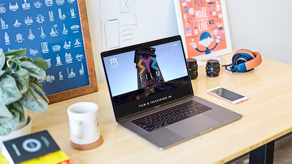 Film Syracuse's Microsite is visible on a laptop sitting on a desk.