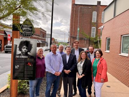 group of people around a Jimi Hendrix sign