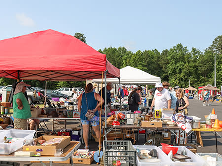 A family search a vendor booth in a parking lot during the 301 Endless Yard Sale.