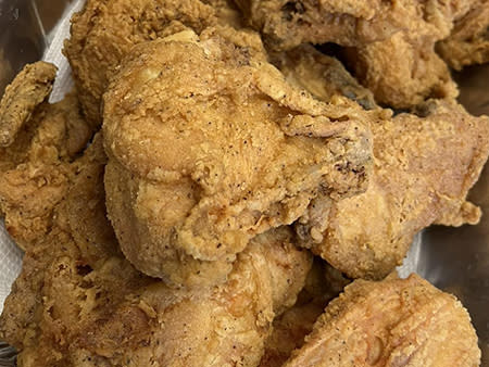 Fried chicken thighs and breast sit in a catering tin at Barefoot's Country Store & Grill.