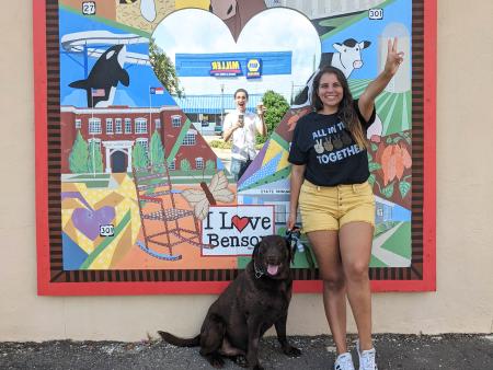 Woman Posing with Dog in Front of Benson Mural with Mirror in the Center