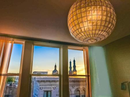 chandelier light on ceiling and view of skyline from window at room in Hotel Covington