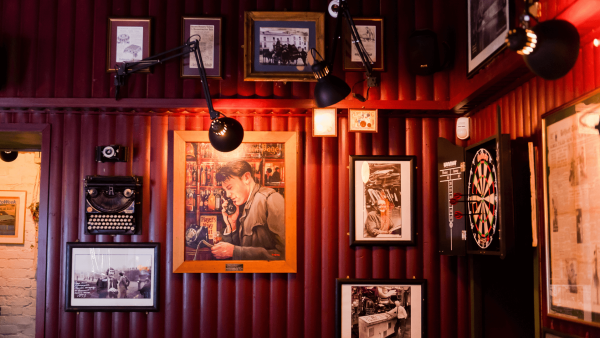 Interior of The Reporter Bar with photos hung on the wall and a dartboard.