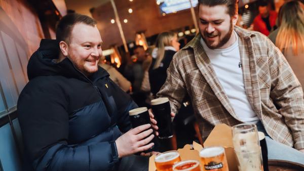 Photo of two men enjoying a Guinness in Haymarket, a bar in Belfast.