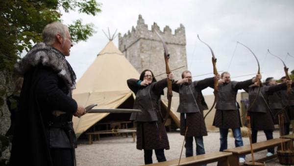Group of people firing bows and arrows as part of Winterfell Tours Game of Thrones experience.