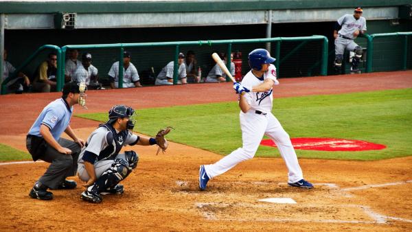 Chattanooga Lookouts player swings bat with catcher and umpire behind him