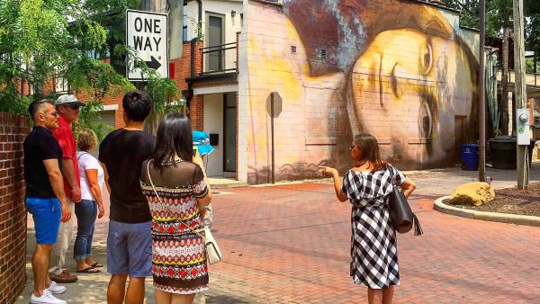 Group stands outside in front of Short North mural