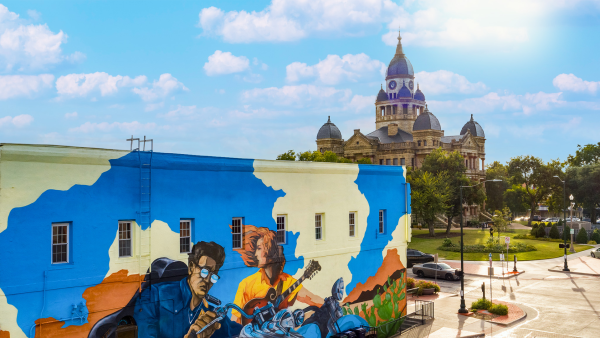 Mural of a motorcyclist and guitarist with Denton courthouse in the background