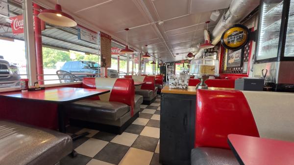 A photo of the retro 50's inspired diner interior of Ed Walker's featuring red leather booths and a checkered tiled floor in Fort Smith, Arkansas