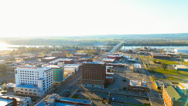 The sun peeks over the Arkansas River and bathes downtown Fort Smith in summer rays.