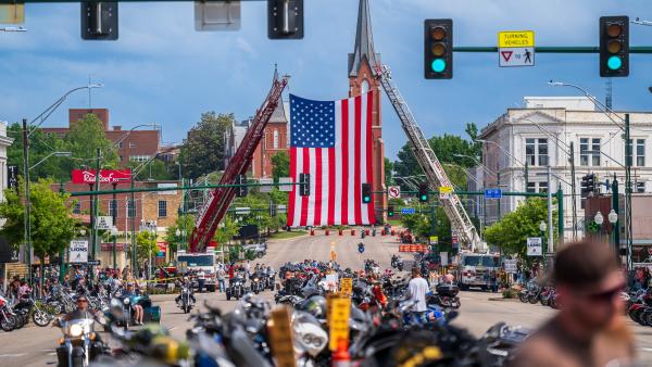 Motorcycles line the center of Garrison Avenue while a large American Flag hangs over the center of the street during the Steel Horse Rally in Fort Smith, Arkansas.