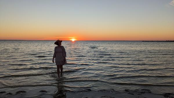 A woman walks in the shallow waters of St. Joseph Bay at Sunset