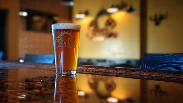 A glass of Copperz beer sits on the bar.