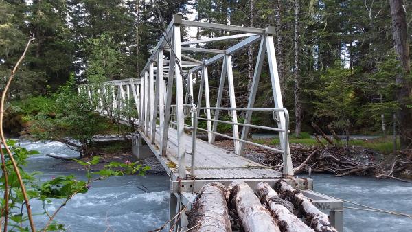 a metal and wood bridge over a creek