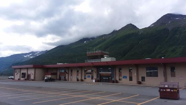 a small airport on a cloudy day; mountains in background