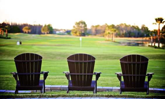 Three Adirondack chairs overlook the beautiful greens at LPGA International world-class golf course