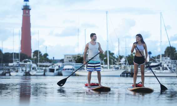 Paddleboarding Couple by Lighthouse