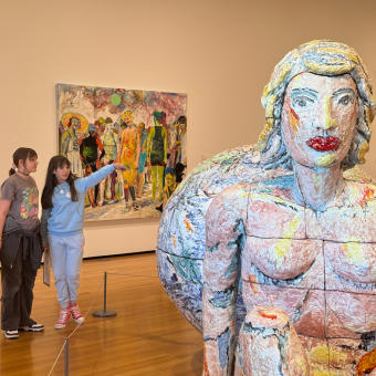 Two young women examining a piece of art at the Akron Art Museum.