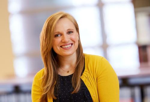 Smiling woman wearing a bright yellow cardigan and black shirt