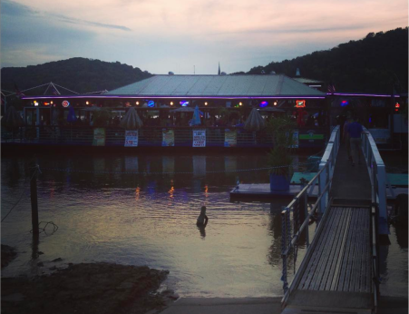 photo of sun setting on ohio river behind the floating restaurant ludlow bromley yacht club