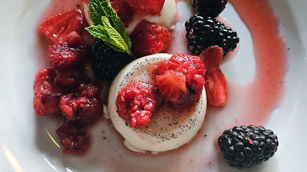 Creamy panna cotta on a plate with fresh berries at Gatsby's Landing