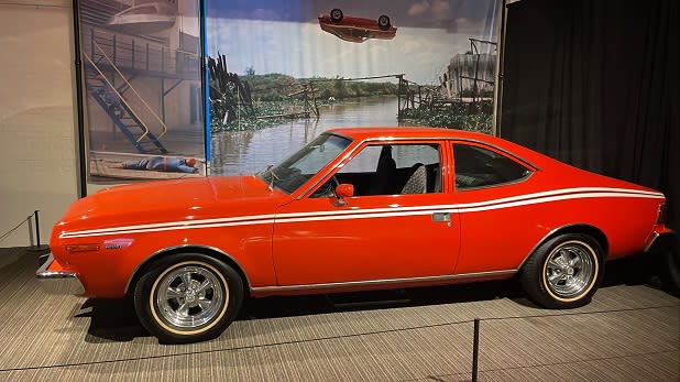 A red car with a white racing stripe at the James Bond exhibit at the Saratoga Automobile Museum