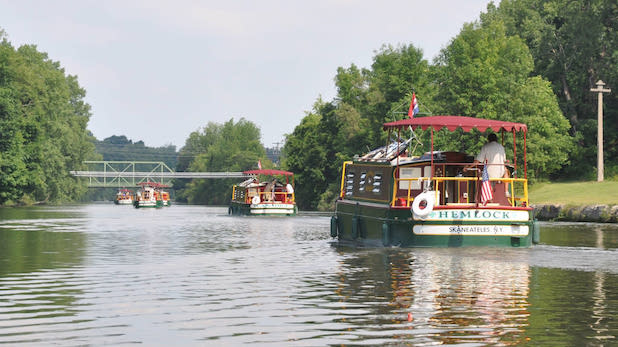 three boats cruise down the Erie Canal