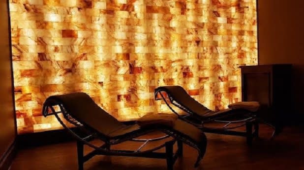 Two reclining lounge chairs illuminated by the orange glow of a salt cave