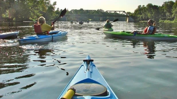 POV of a person paddling in a group towards a lift bridge on the Oswego Canal