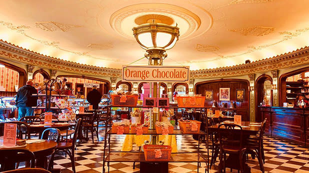 A display of orange candy in the center of a black and white tiled floor under a domed ceiling light at Parkside Candy in Buffalo