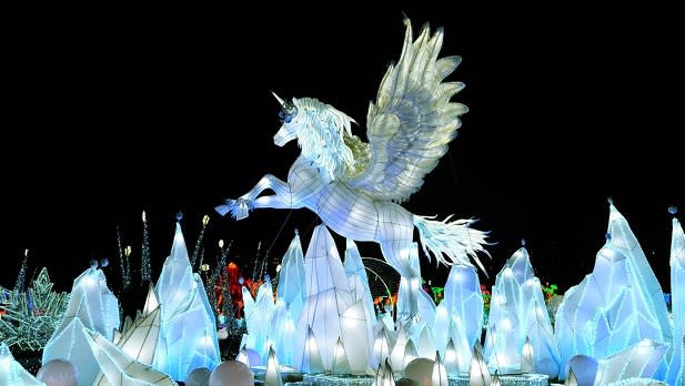 A prancing white unicorn with its wings spread as if it about to take flight at the LuminoCity Festival