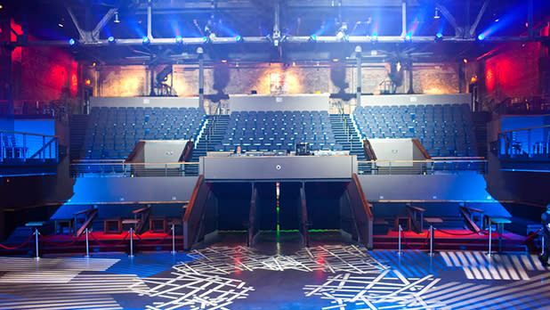 View of the seating at a performance venue lit up with red and blue spotlights