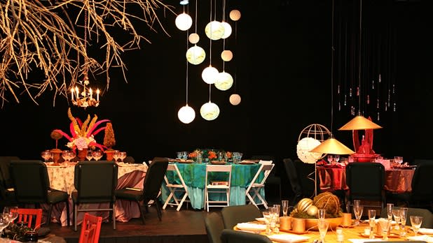Colorful tables and chairs sit in a room decorated with unique lighting and other art