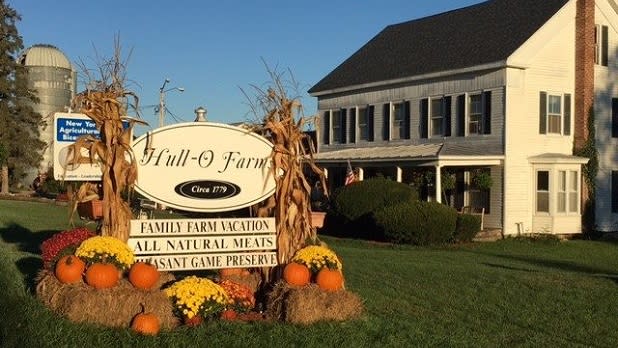 Pumpkins and hay bales decorate the Hull-O-Farms sign in the Catskills