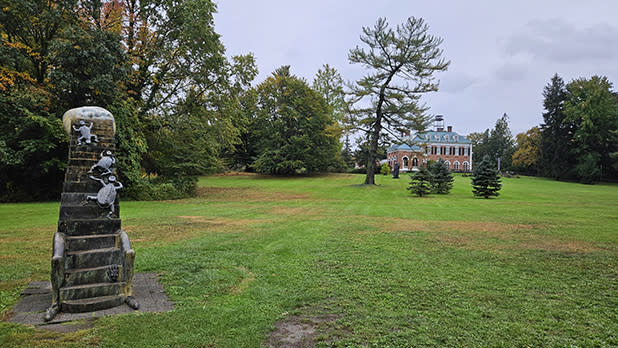 A sculpture stands on a green lawn outside the Frick Estate mansion of the Nassau County Museum of Art