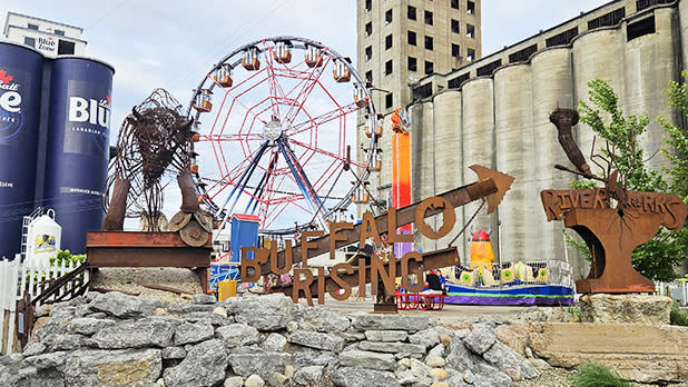 A tall building with a colorful Ferris wheel in front at the RiverWorks entertainment complex.