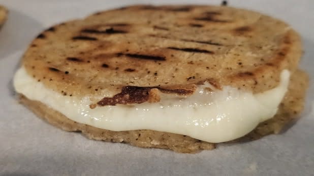 An arepa with cheese and garlic aioli,