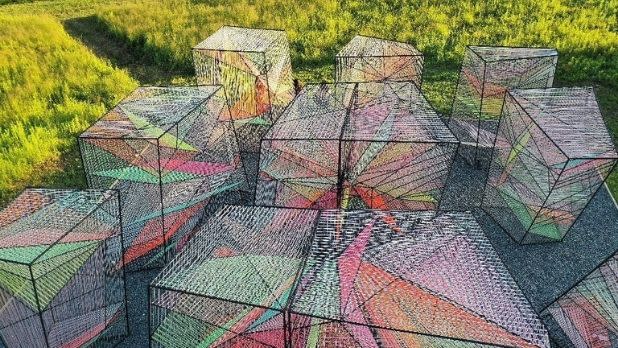 Multicolored sculptures next to a sunny field at Art Omi
