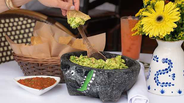 A bowl of guacamole and chips at Besito