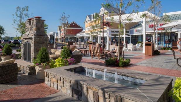 Various storefronts at the Tanger Outlets in Riverhead from a stone sitting area