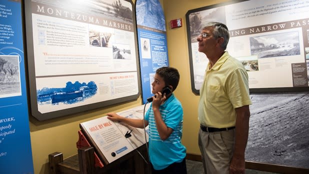 An older man and a boy explore exhibits at the Erie Canal Museum