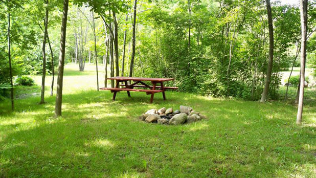 A picnic table and fire pit at Cherry Hill Campground