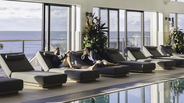 A couple sits on lounge chairs at the Seawater Spa in Gurney's Montauk Resort