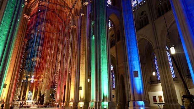 Interior of the Cathedral of St. John the Divine illuminated with Pride lights.