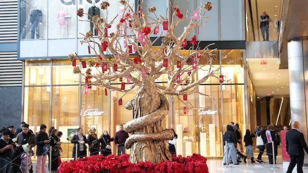 A golden tree with red envelopes dangling from the branches