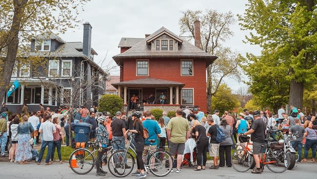 A crowd gathers outside a home as a band plays at Buffalo Porchfest