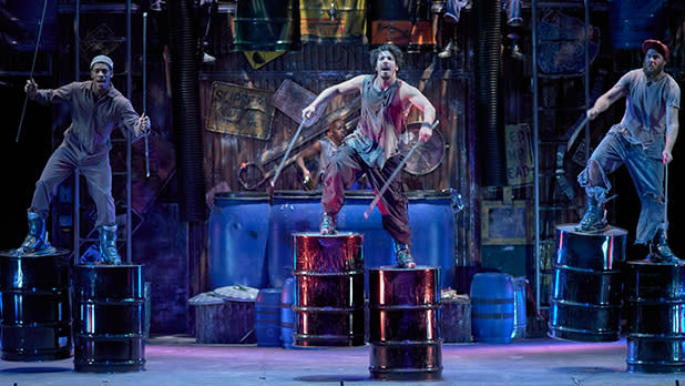 Performers with drumsticks and barrels on stage during Stomp