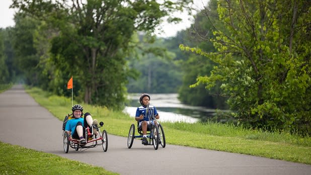 Two people using adaptive bicycles cruise along the Erie Canalway Trail