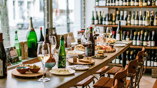 A table set with plates of food and wine bottles